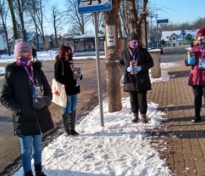 Cztery kobiety wolontariuszki WOŚP stoją na ulicy miasta.