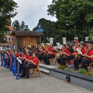 Orkiestra dęta ZHP - OSP Uniejów. Przed orkiestrą stoi dyrygent.
